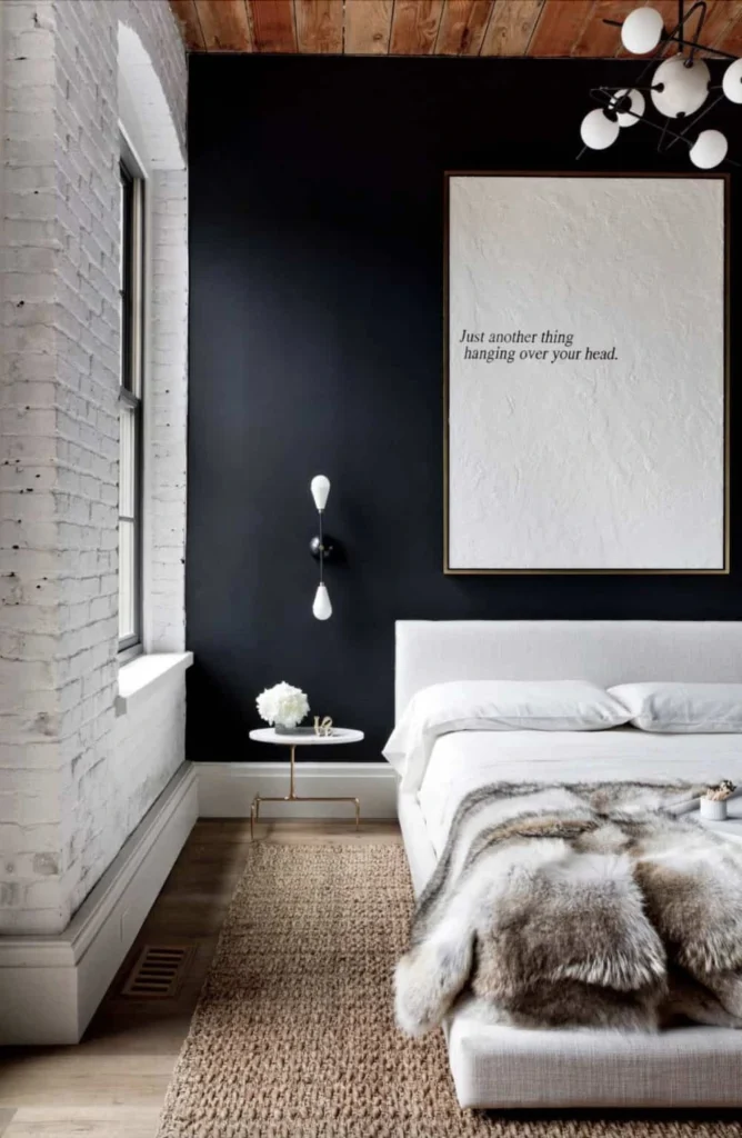 Quarto Boho Escandinavo com parede preta, cama branca minimalista e manta de pele sintética.