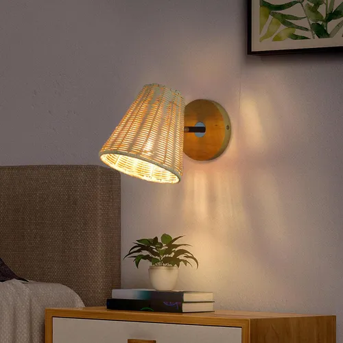 Abajur de parede em palha natural com suporte dourado iluminando mesa de cabeceira