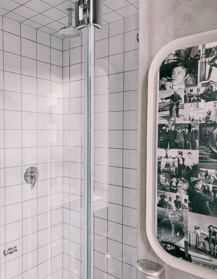 Banheiro pequeno moderno com box de vidro, azulejos brancos tipo subway e chuveiro cromado