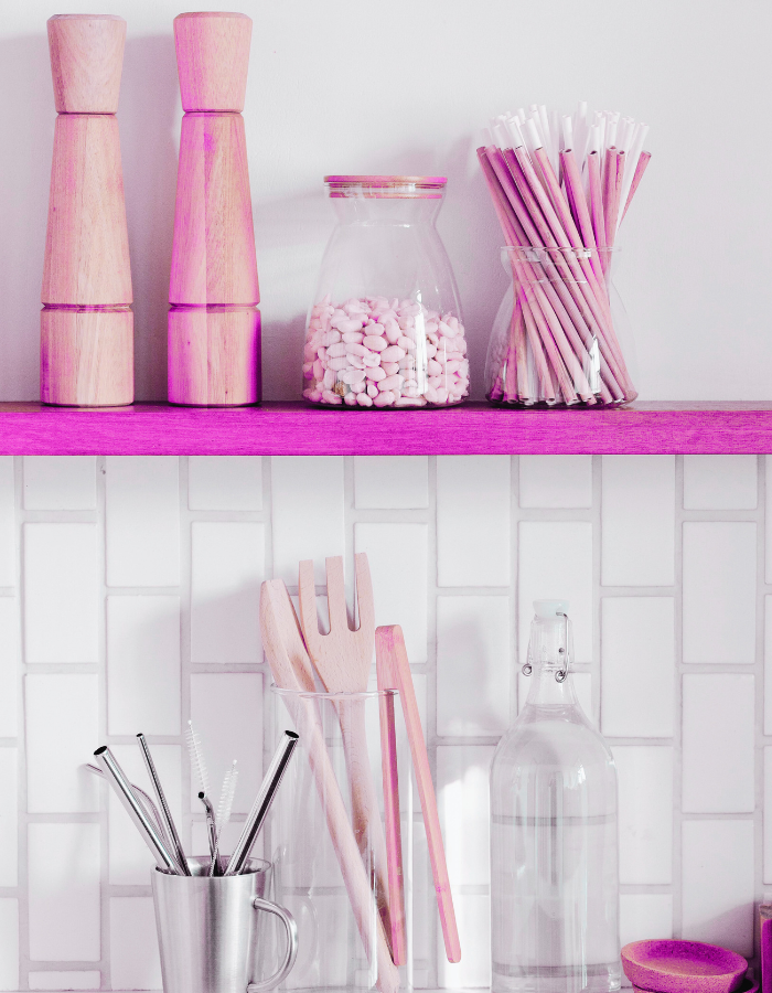 Decoração de cozinha rosa com utensílios organizados em potes de vidro sobre prateleira
